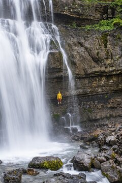 Adventure, Little hiker under large Cascata di Mezzo waterfall, long exposure, Vallesinella, Brenta, Trentino, Italy
