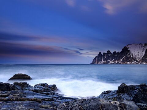 Granite beach, Devils Teeth mountain peak behind, Okshornan mountain range, Tungeneset, Senja Island, Troms, Norway