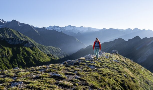 Hiker enjoying the mountain panorama in the morning, Venediger group, behind Dreiherrenkopf, Simonysitze and Gro&szlig;er Geiger, Hohen Tauern, Austria