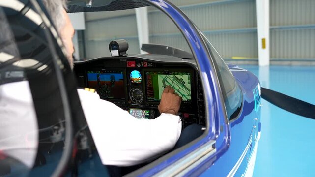 Pilot operating touchscreen navigation system in airplane cockpit