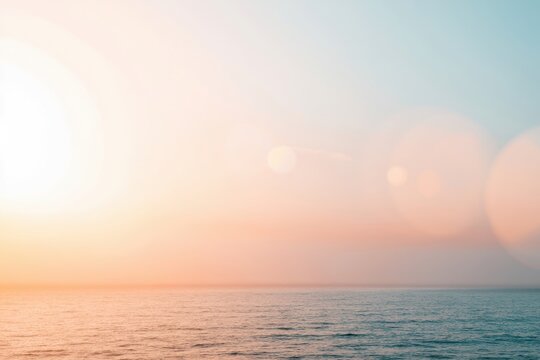 The Ocean at Sunrise with a Pastel Sky and Gentle Lens Flare Over Water