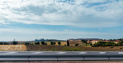Fototapeta premium Driving through the rural Toledo landscape with industrial buildings