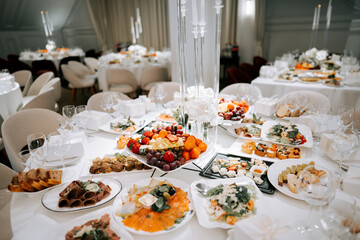 Fototapeta premium Elegant white table spread with diverse dishes for a formal reception
