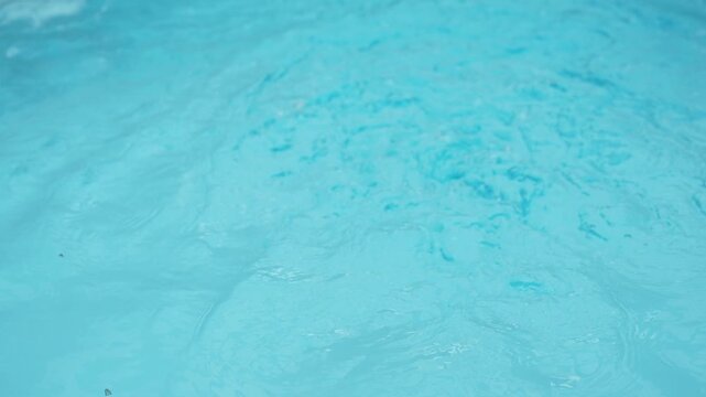 Rippling turquoise water surface creating a tranquil texture with gentle waves and calming movement, ideal for background use in spas, wellness and relaxation concepts
