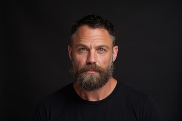 Obraz premium The bearded man with intense blue eyes looking into camera in studio portrait