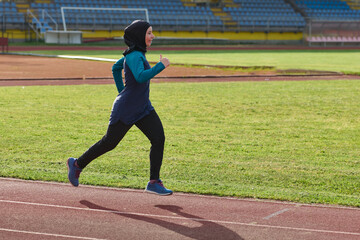 Fototapeta premium Female Hijab Runner Training on Outdoor Track for Fitness and Healthy Active Lifestyle