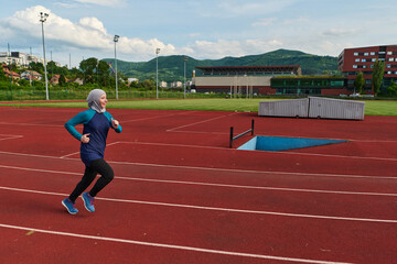 Fototapeta premium Muslim Woman Running on Outdoor Track in Hijab for Fitness and Healthy Lifestyle Training