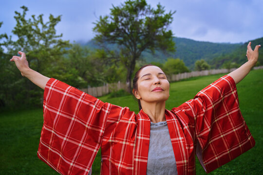 Woman practicing mindfulness and breathing fresh air in the countryside