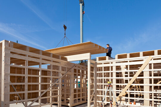 Europe, Germany, Rhineland Palantinate, Man installing and fixing wooden walls of prefabricated house