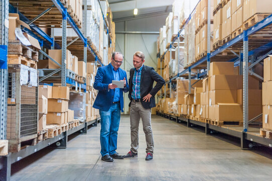 Two managers discussing packaging and shipment in storage hall