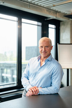 Smiling managing director portrait in modern office setting