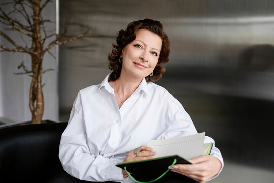 Smiling businesswoman with a notebook in modern office