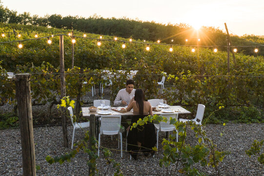 Italy, Tuscany, Siena, young couple having dinner in a vineyard