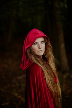 Portrait of a fantasy character wearing a red hood in a forest