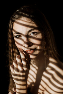 Artistic close-up portrait with striped shadow pattern on face