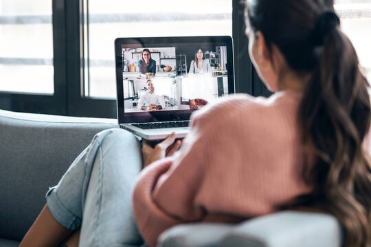 Student relaxing on sofa during a casual video call on laptop