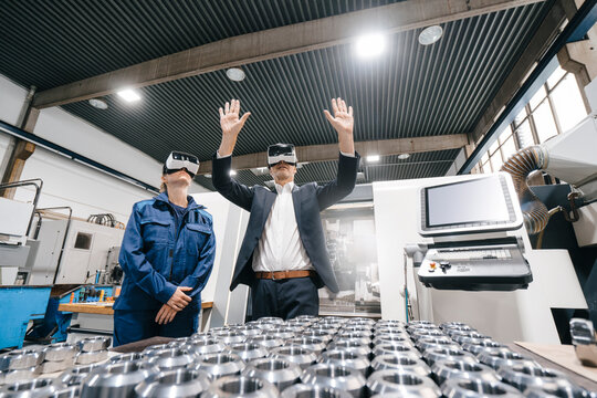 Businessman and skilled worker in high tech enterprise, using VR glasses