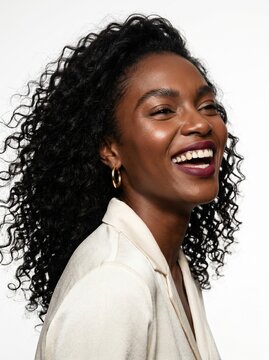 Fashion portrait of a dark skinned woman with black natural curly hair. Perfectly groomed, yet retaining natural definition. Isolated on white background.