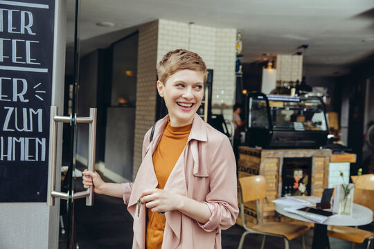 Female cafe owner unlocking the door in the morning