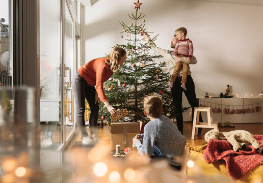 Family decorating Christmas tree