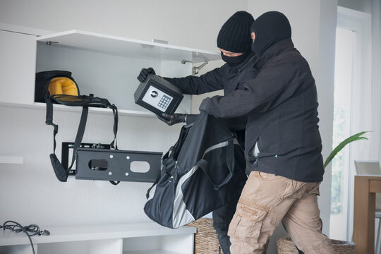Two burglars at work in an one-family house at daytime