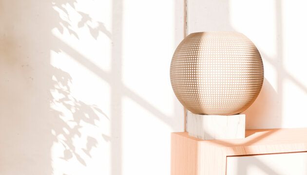 Modern spherical lamp on wooden cabinet with leaf shadow on wall