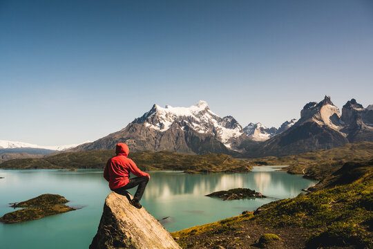 Man in hooded jacket looking at view of Lake Pehoe in Torres Del Paine National Park, Chile Patagonia, South America