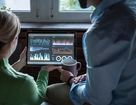 Colleagues analyzing financial data on a tablet in the office