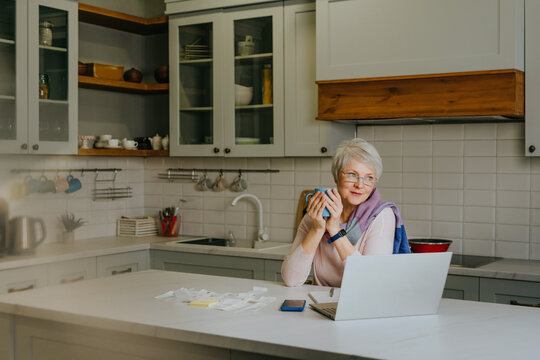 Woman relaxing with coffee and laptop in the kitchen