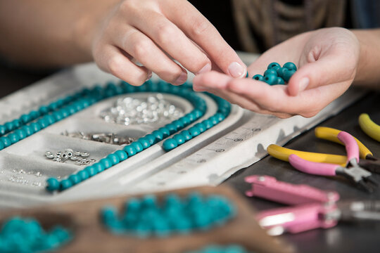 Close-up of woman working with beads to create a necklace