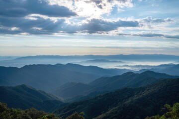 Obraz premium The mountain range at dawn with layered ridges misty valleys and sunbeams