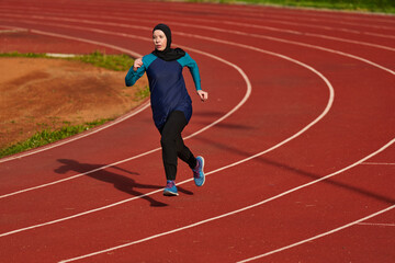 Fototapeta premium Female Athlete Running On Outdoor Track In Headscarf Training For Fitness And Endurance