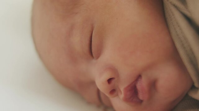 Newborn Tranquility: A close-up shot captures the serene slumber of a newborn baby, emphasizing delicate features and peaceful innocence.