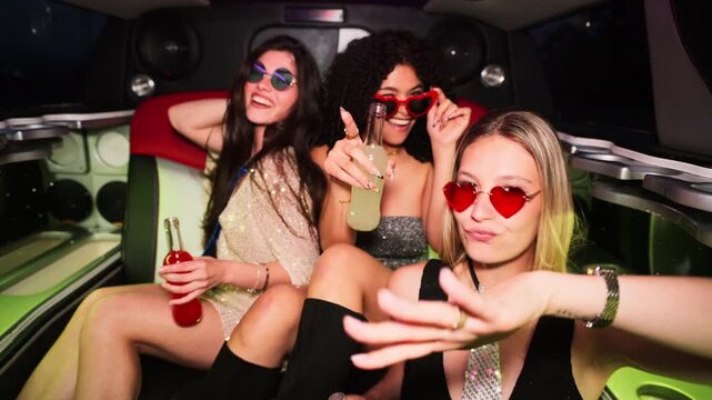 Fashionable girls partying inside a limousine at night