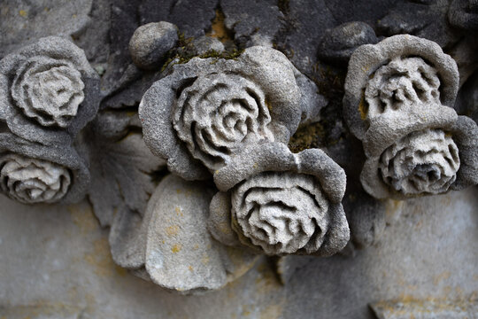 D&eacute;tail d'une guirlande de roses en pierre sculpt&eacute;e sur une tombe