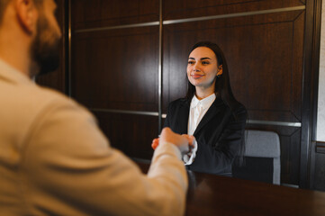 Hotel receptionist welcoming guest at front desk