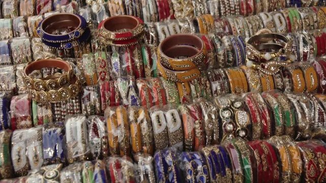 Close-up of numerous vibrant and ornate Indian bangles displayed for sale at a market stall. Traditional bracelets and handmade jewelry showcasing rich craftsmanship and cultural accessories