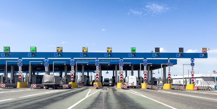 Highway toll plaza with traffic lanes, tollbooths, vehicles, transportation, travel and logistic infrastructure.