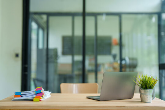 Modern office creating a productive environment with an open-plan workspace. Organizing documents using colorful binder clips for efficient workflow. And clean desk setup with laptop