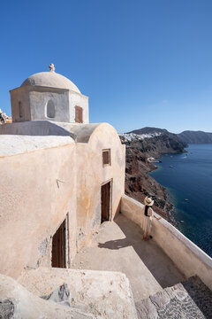 Young woman visiting Fort Londsa and enjoying the view of the caldera, Oia, Island of Santorini, Cyclades, Greece