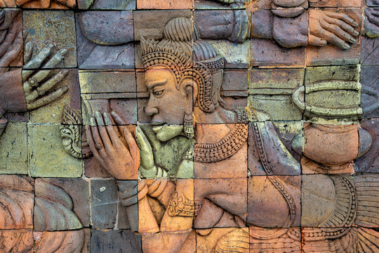 A detailed terracotta bas-relief sculpture depicting a traditional Thai dancer in prayer, Doi Inthanon National Park, Chiang Mai, Thailand. The intricate artwork showcases cultural heritage.