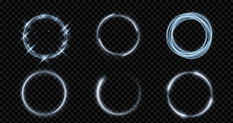 Obraz premium Glowing blue rings with magical sparkles and light trails, abstract vector set on transparent background. Silver neon swirl circles with dust particles, circular frames with flare, shimmering effect