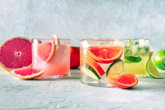 Refreshing summer cocktails with ice cubes on a light background