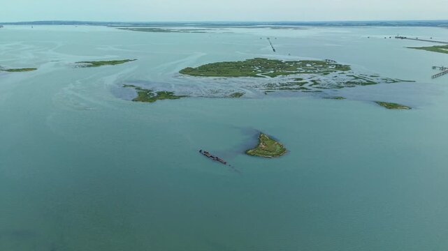 Aerial view of the rusted wreck of a surrendered WW1 German U-boat embedded in the mud flats of the Medway Estuary, Kent, UK.