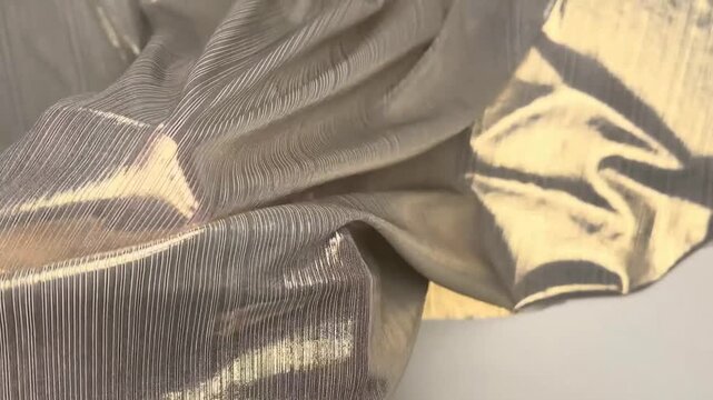 This thin stretchable metallic knit fabric features a highly reflective glossy surface and soft drape perfect for creating statement apparel and luxury costume designs