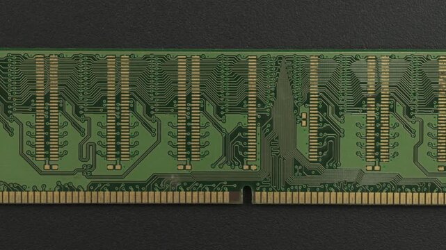 A close examination of a green RAM circuit board showcasing intricate gold connectors and patterns. Ideal for technology presentations or educational content.
