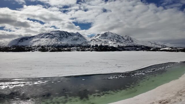 Snow-covered mountains and lake near Carcross, Canada, White Pass Railroad end, gorgeous turquoise waters