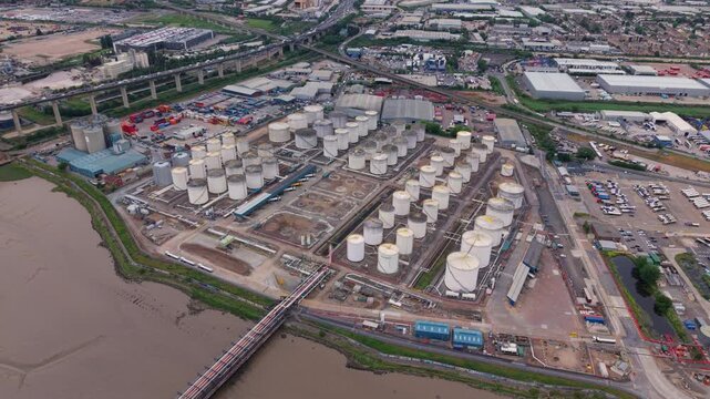 Aerial view of massive oil storage terminal depot with fuel silos on the banks of the River Thames near Dartford Crossing UK