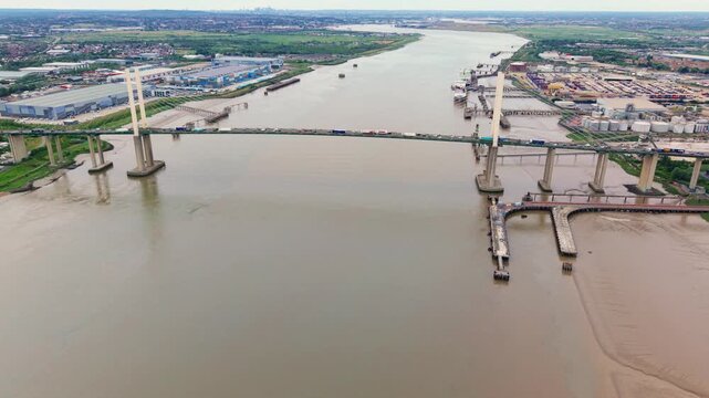 The Queen Elizabeth II bridge spanning River Thames near Dartford with industrial sites on banks, aerial view, UK.