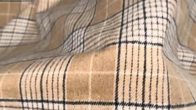 This versatile medium-weight plaid fabric features a classic tan and cream grid pattern with a sturdy feel suitable for tailoring professional suits blazers and structured autumnal skirts